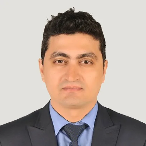 Man in suit and tie against light background.